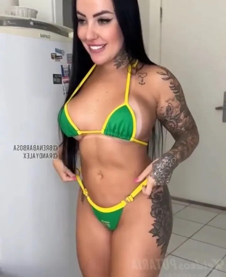 Hot tattooed brunette in her green bikini showing her beautiful body